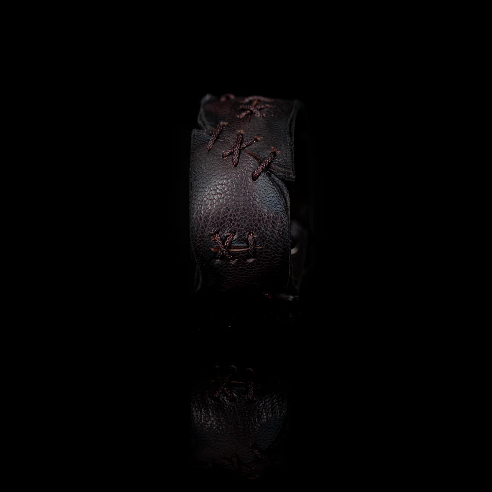 Black genuine leather cuff bracelet with hand-laced stitch detailing, raw cut edges, and a handcrafted artisan design, displayed on a white background.
