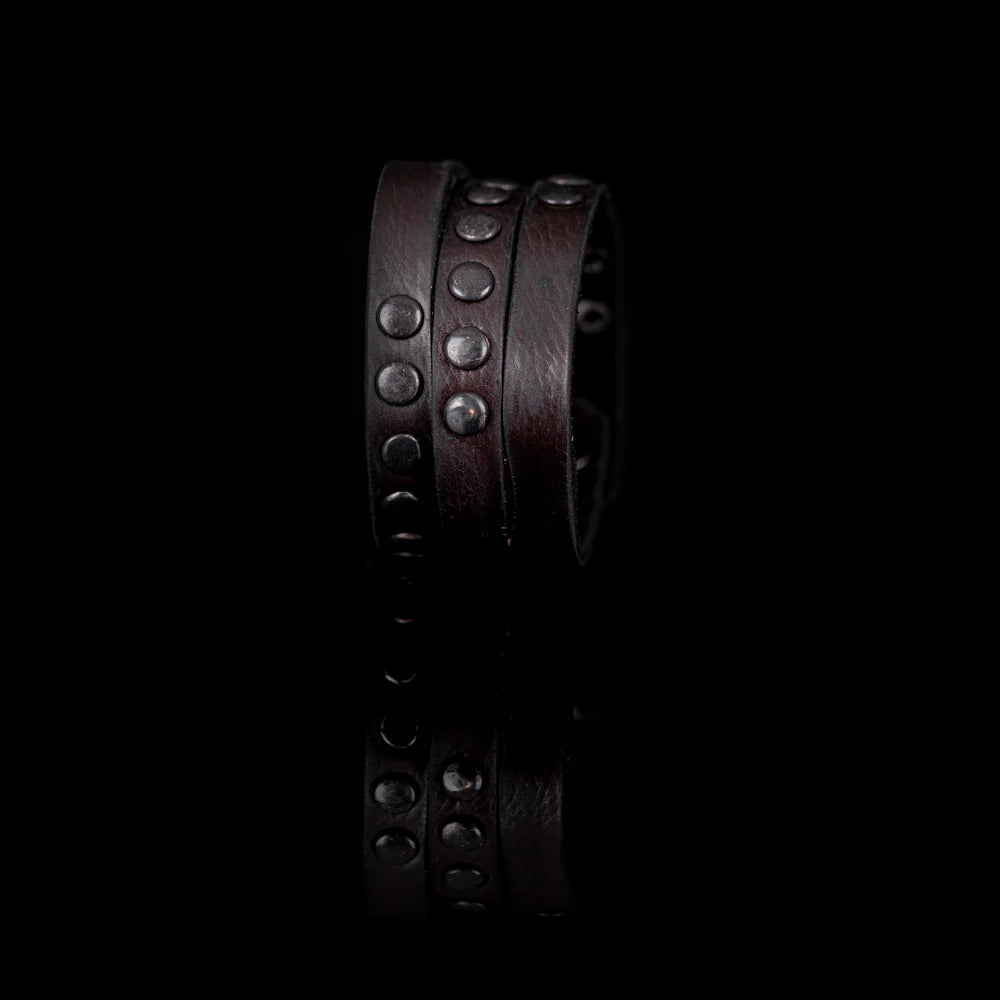 Black genuine leather wrap bracelet featuring layered leather bands with black rivet detailing and a handcrafted rugged design, displayed on a white background.