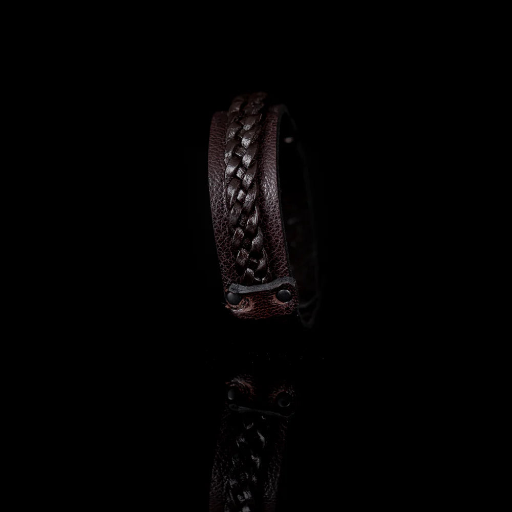 Men's handcrafted genuine leather cuff bracelet in dark brown featuring a woven braided leather center panel, matte black rivet accents, and a sleek minimalist design. Premium artisan men's leather wristband photographed on a clean white background.
