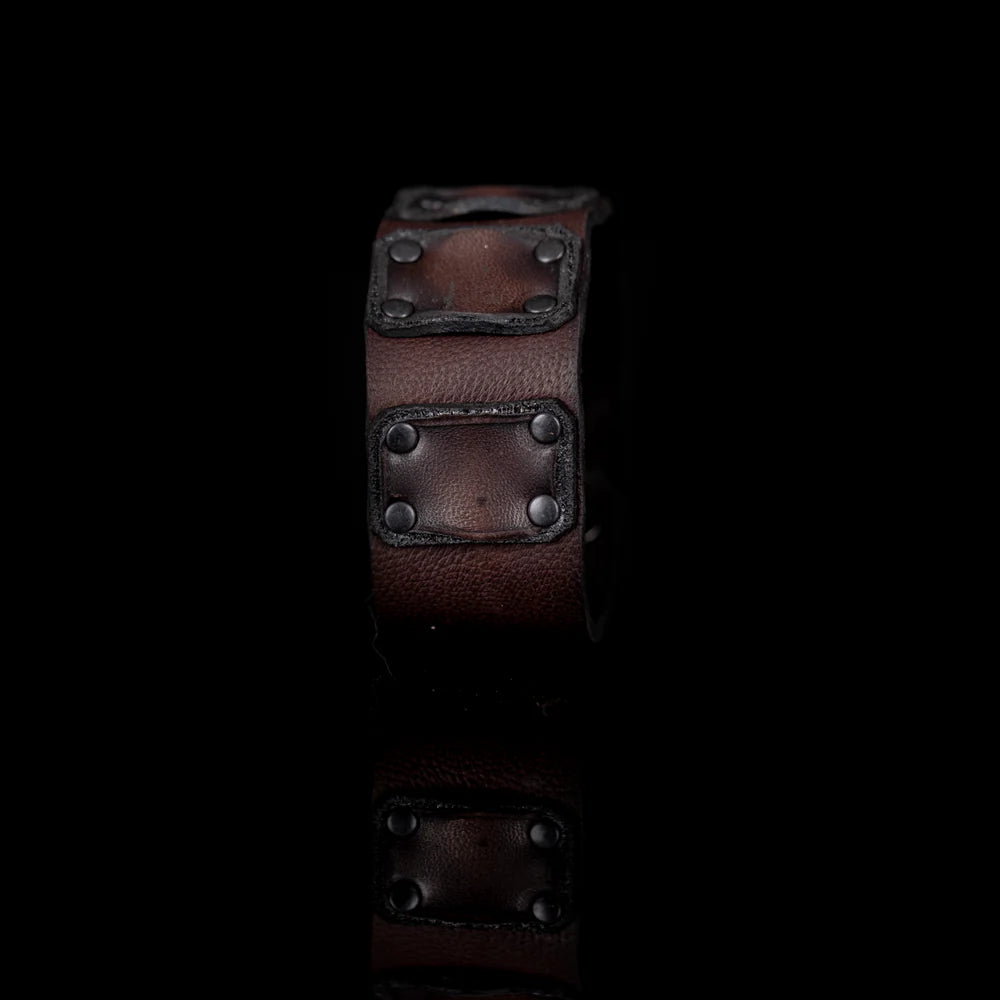 Men's handcrafted genuine leather cuff bracelet in dark brown featuring a wide minimalist design with layered leather panels, matte black rivet detailing, and premium artisan craftsmanship. Luxury men's leather wristband photographed on a clean white background.