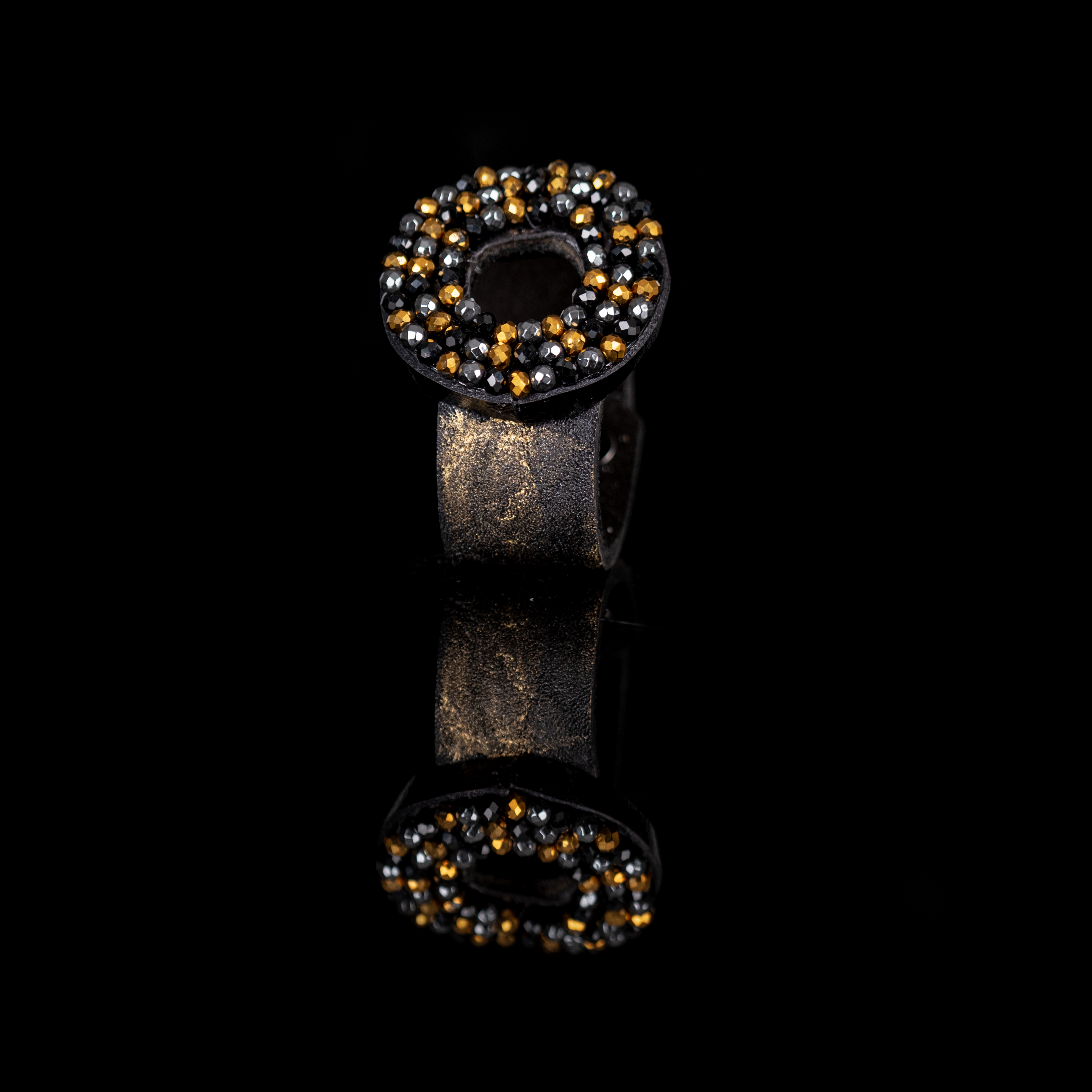 Black leather cuff bracelet with circular halo of black, gunmetal and gold crystals, handmade statement bracelet by THE DARK