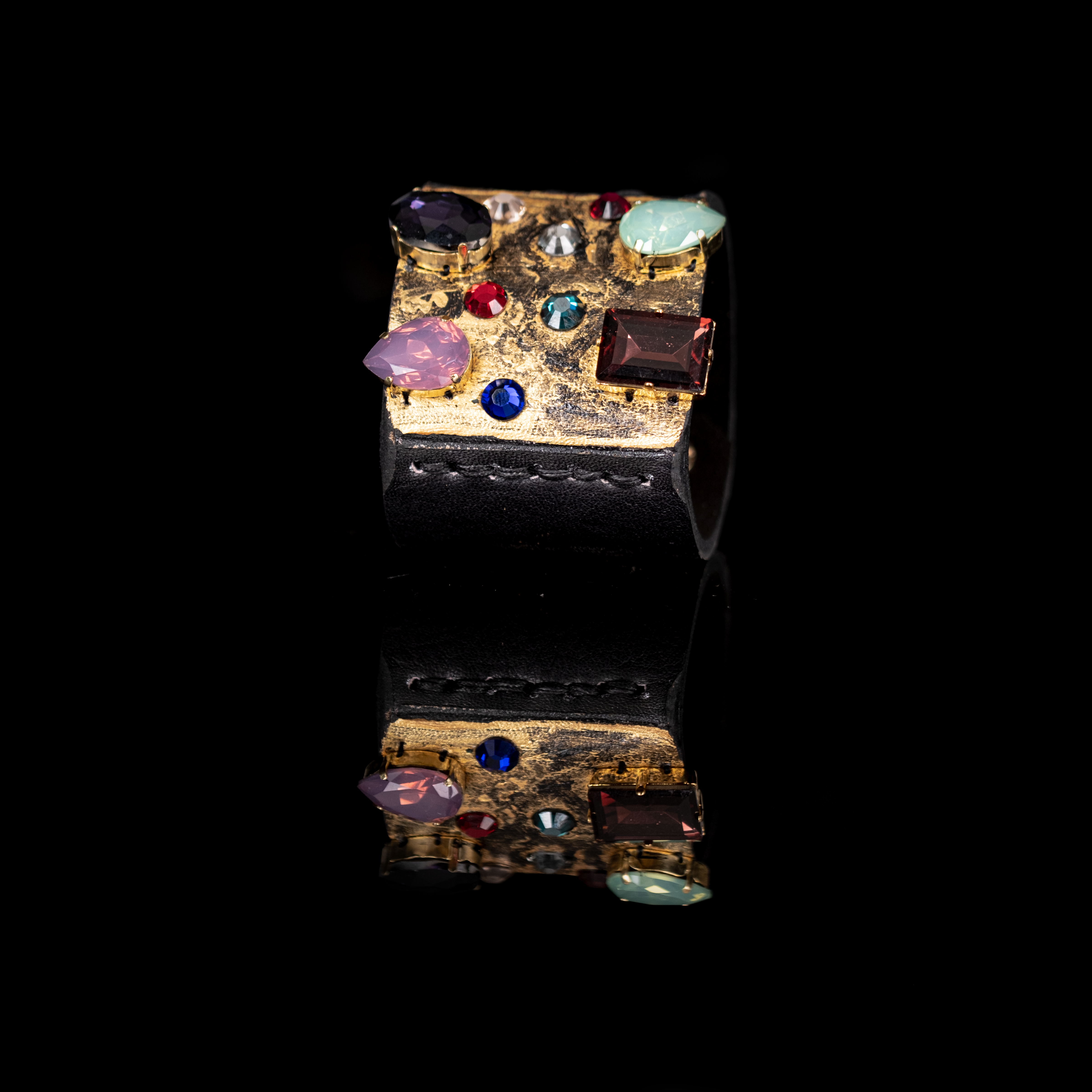 Black leather cuff with gold textured surface and multicolor crystal embellishments, statement bracelet