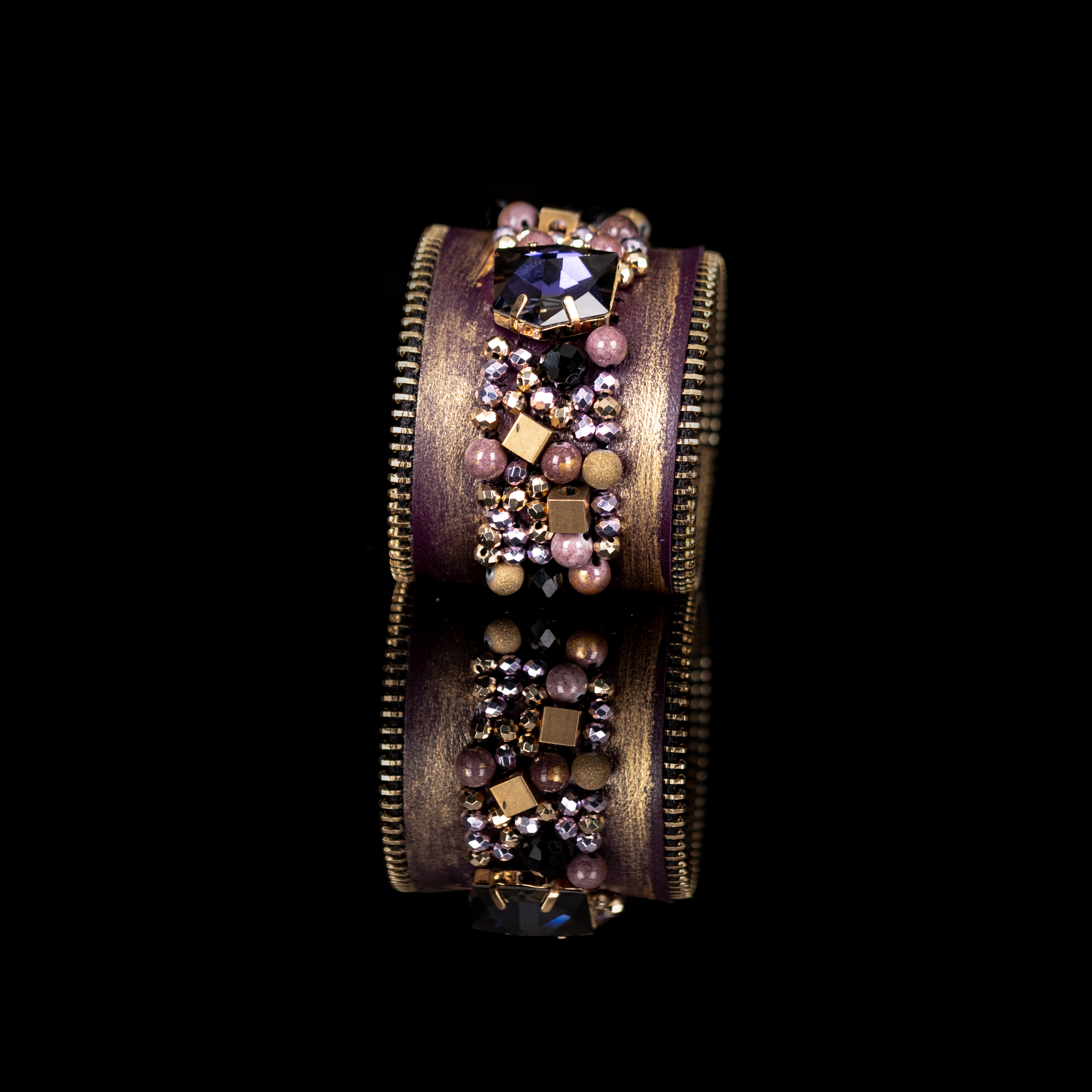Gold brushed leather cuff with zipper edges and central crystal cluster embellishment, statement bracelet