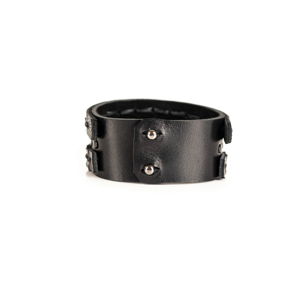 Black genuine leather bracelet featuring layered hand-stitched straps, black studded detailing, and geometric cut leather accents, handcrafted statement accessory on a white background.