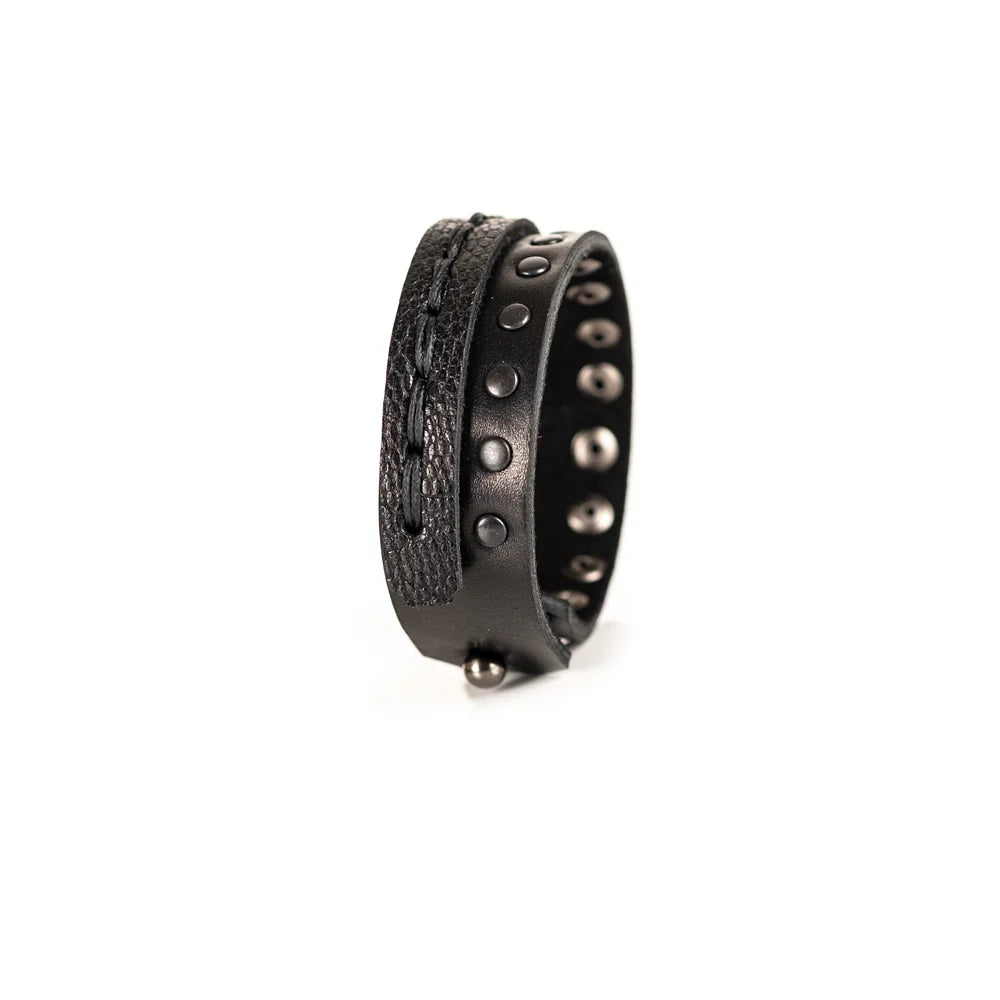 Black genuine leather bracelet featuring a hand-stitched leather band layered with a black studded strap, handcrafted statement accessory on a white background.