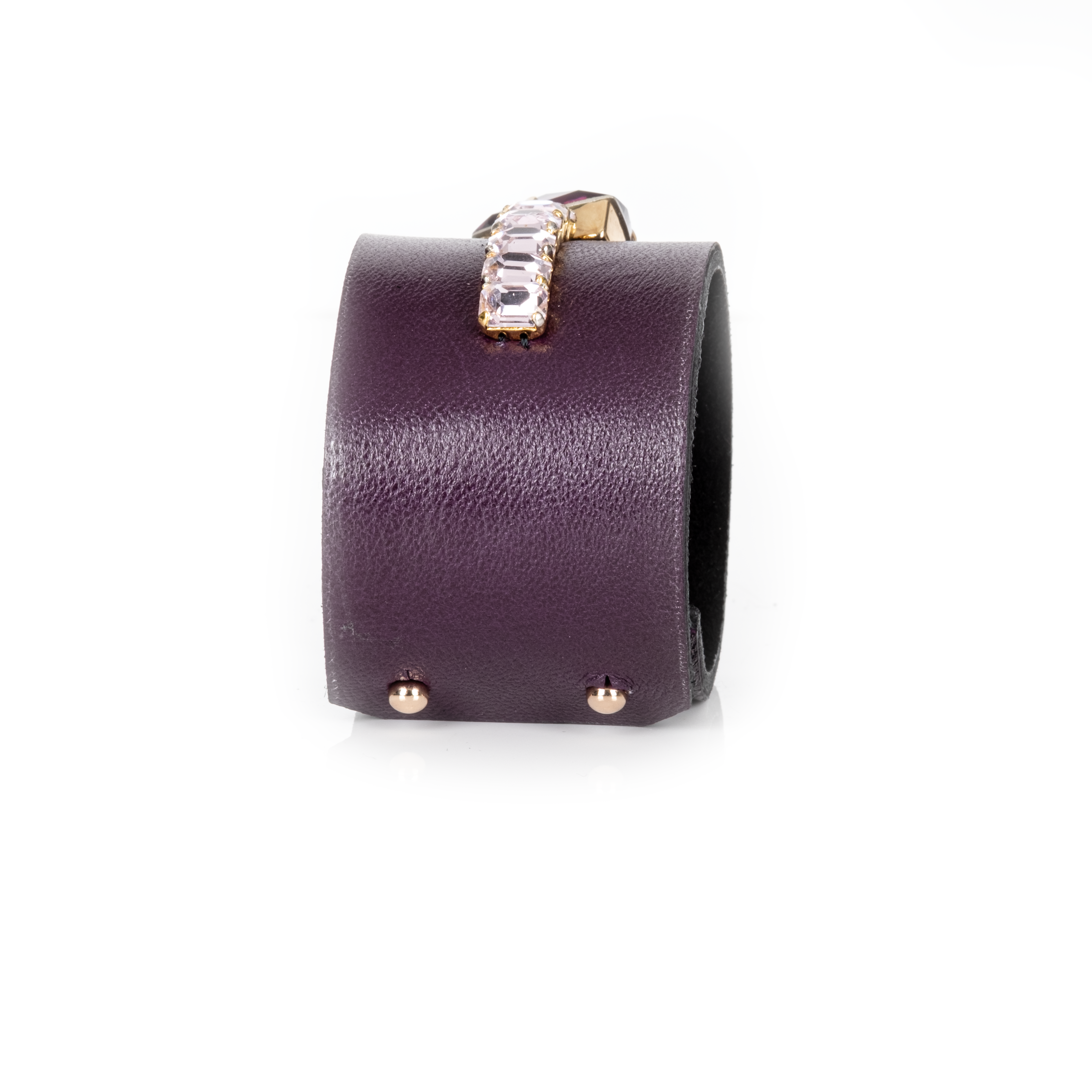 Purple leather cuff bracelet with gold accents on a white background