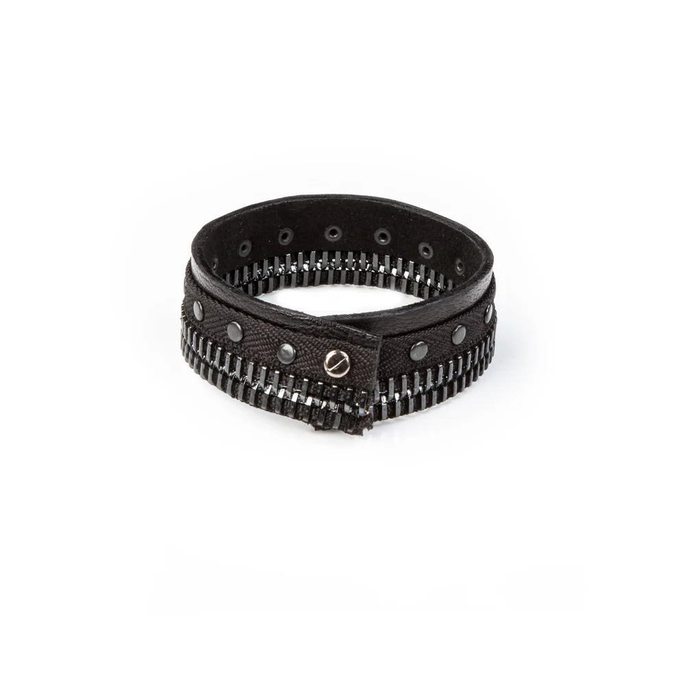 Men's black leather cuff bracelet featuring gunmetal zipper detailing, black metal studs, and layered textured leather bands for a bold industrial-inspired luxury look.