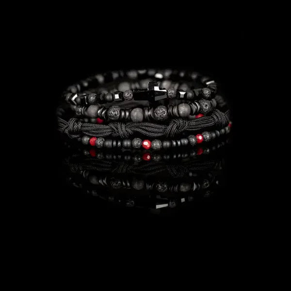 Layered men’s bracelet set featuring black lava stone beads, faceted black crystal beads, matte gray stone beads, braided black cord wraps, red accent beads, and a black arrow-shaped centerpiece, displayed on a white background.