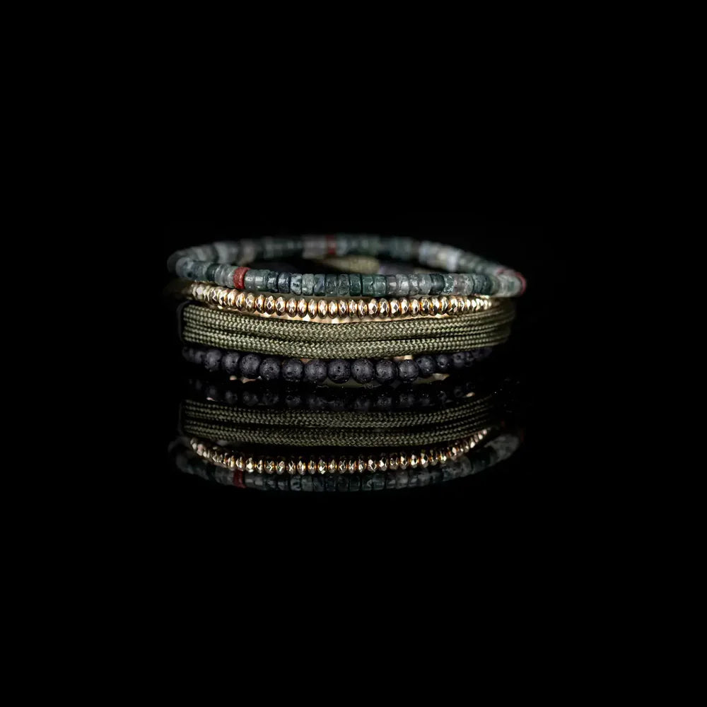 Layered men’s bracelet set featuring green cord with a black anchor clasp, lava stone beads, gold-tone crystal beads, and natural stone heishi beads in earthy green and gray tones, displayed on a white background.