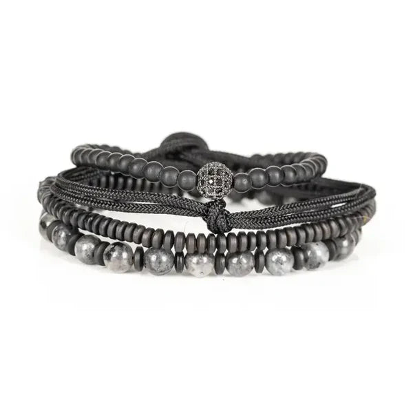 Men's layered black and gray beaded bracelet set featuring matte black beads, natural stone beads, hematite spacers, braided cord strands, and a pavé crystal accent bead in a modern luxury design.