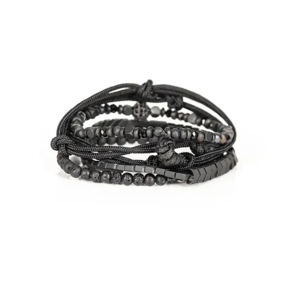 Black layered men’s bracelet with lava stone beads, hematite accents, braided cord, and adjustable closure on a white background.